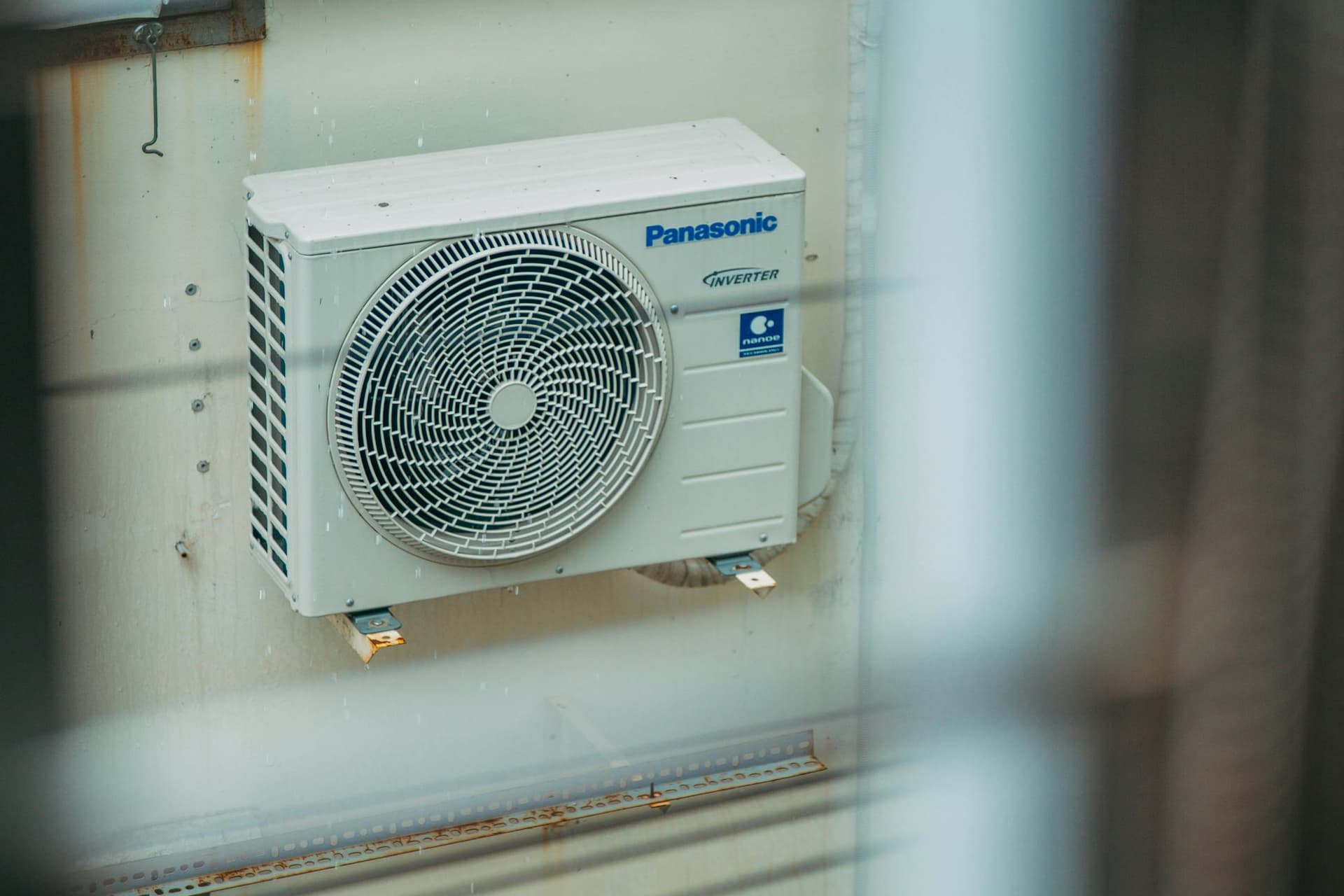 Heat pump outdoor unit beside a home's exterior wall