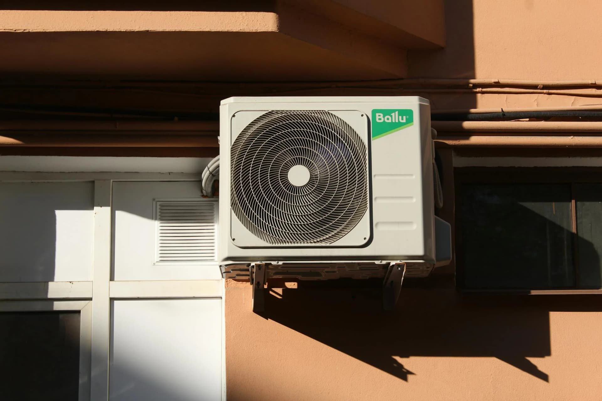 Heat pump condenser unit mounted above grade for winter clearance