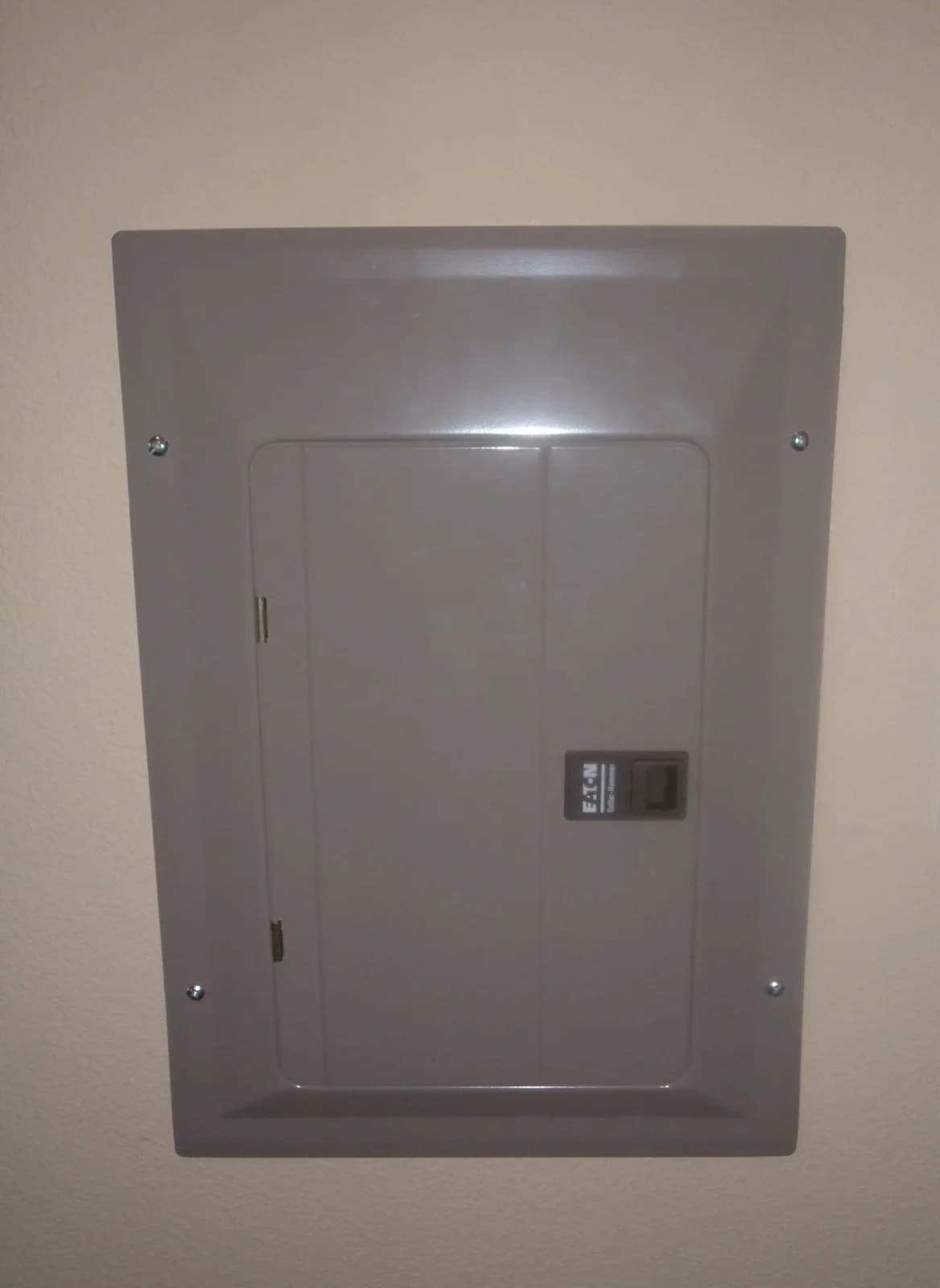 Residential breaker panel with the cover closed on a finished wall