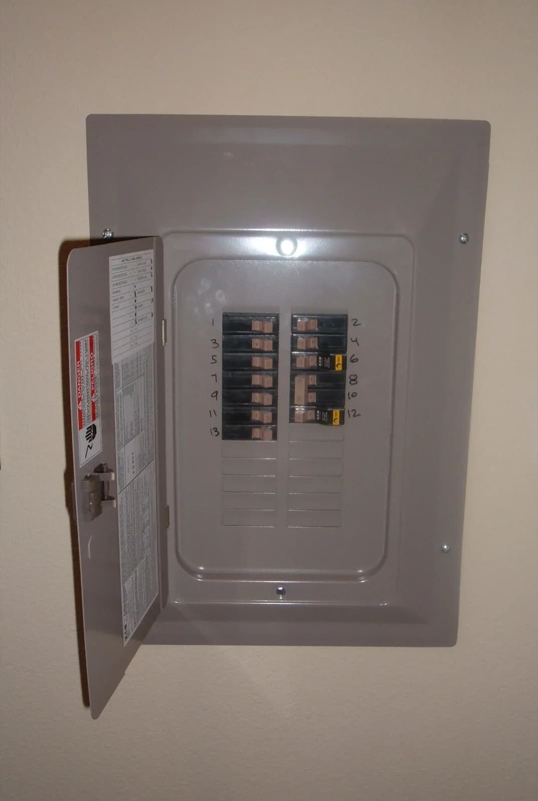 Residential breaker panel with the door open showing labeled circuit breakers