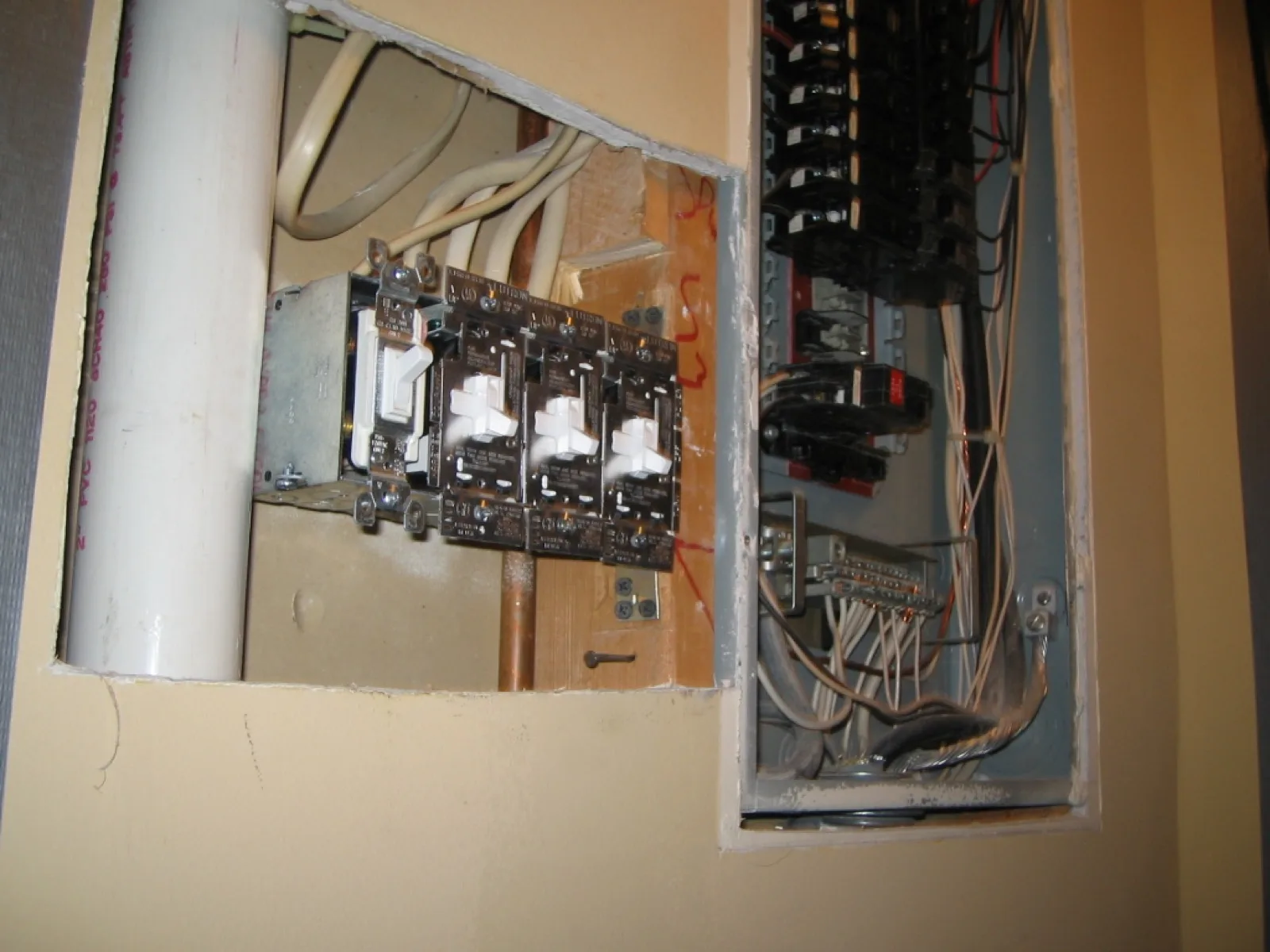 Older fused panel next to a newer breaker panel during a service upgrade