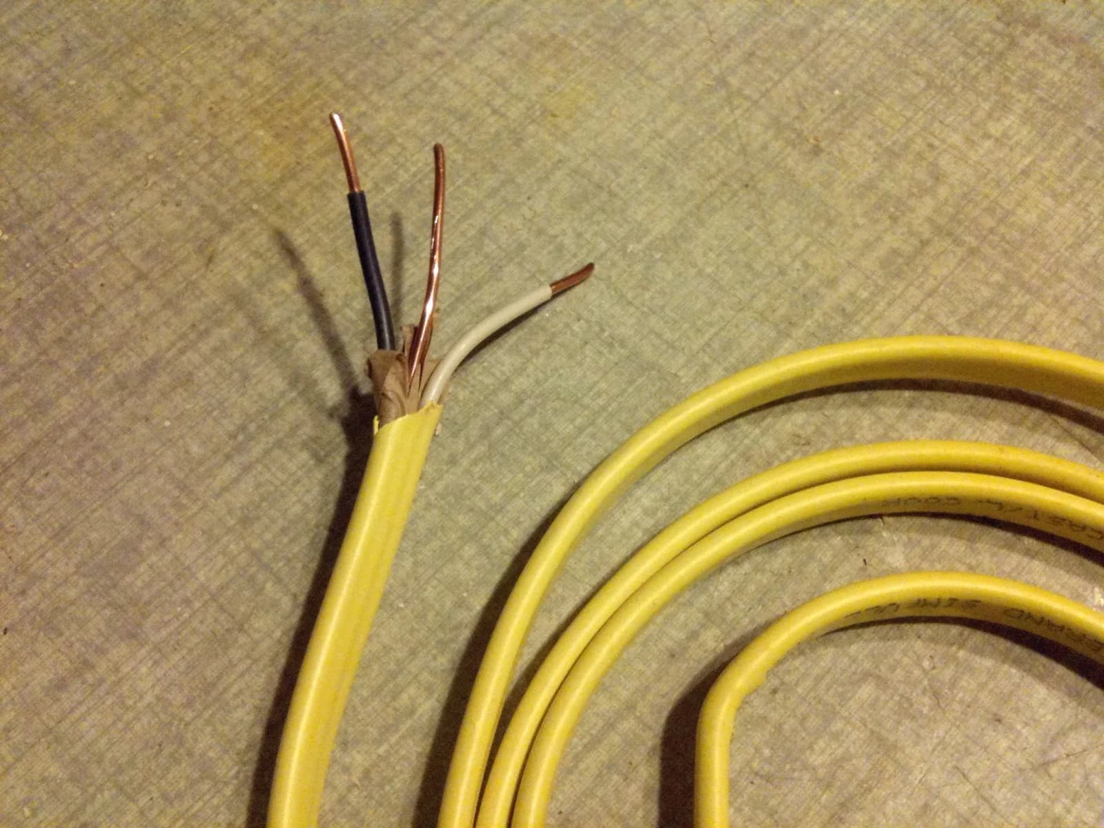 Yellow NM-B Romex cable with the conductors exposed