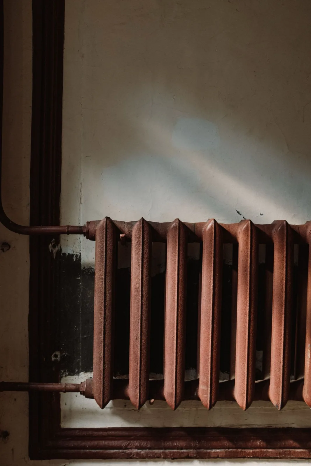 Older cast iron radiator with its supply valve, the type of hydronic heat common in older Maine homes
