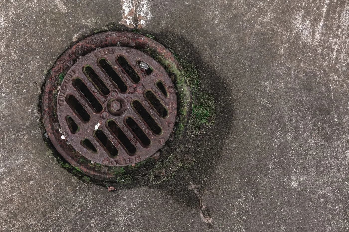 Rusted outdoor drain grate set in concrete