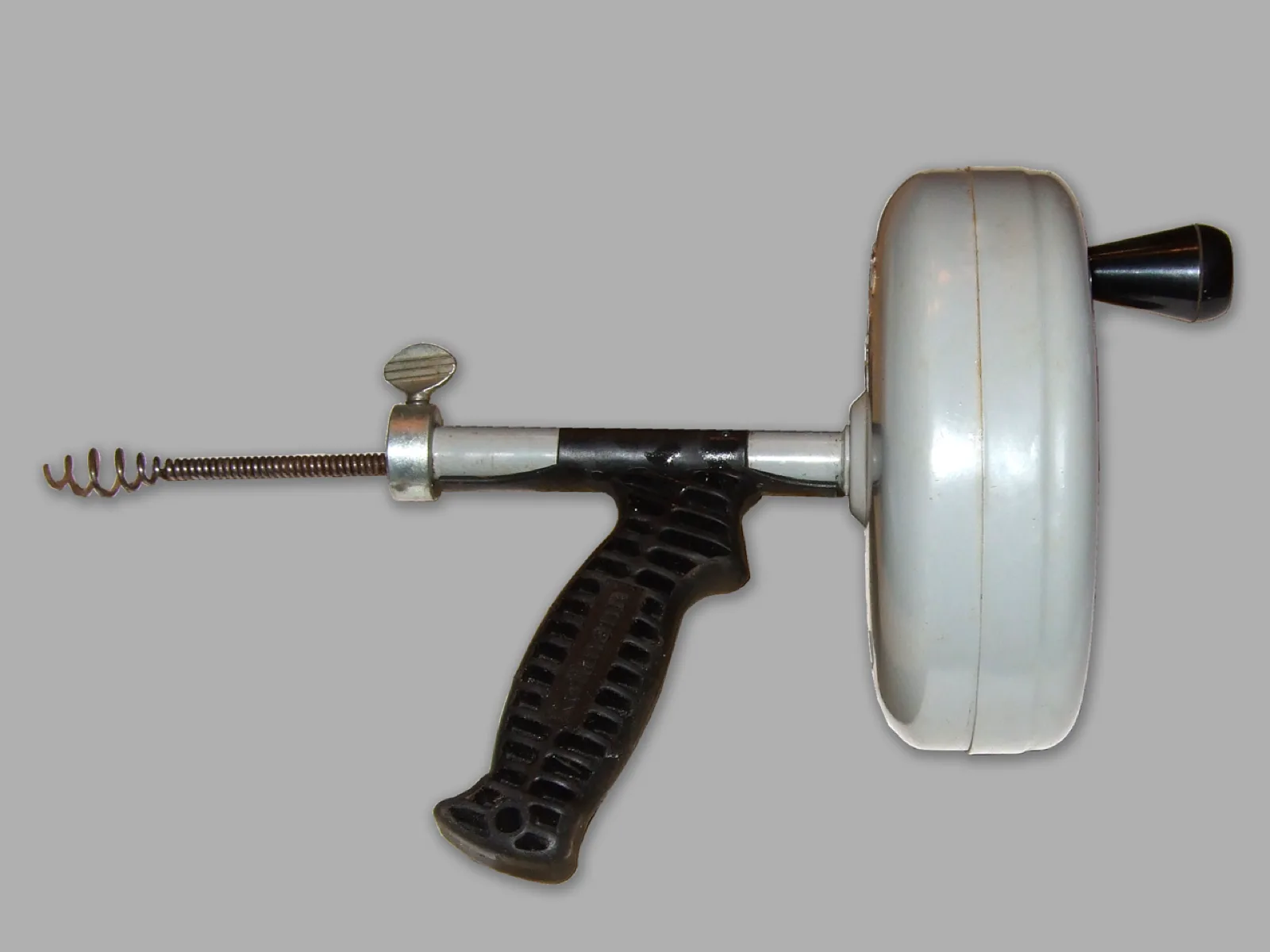 Hand-crank drain auger used to clear a clogged line