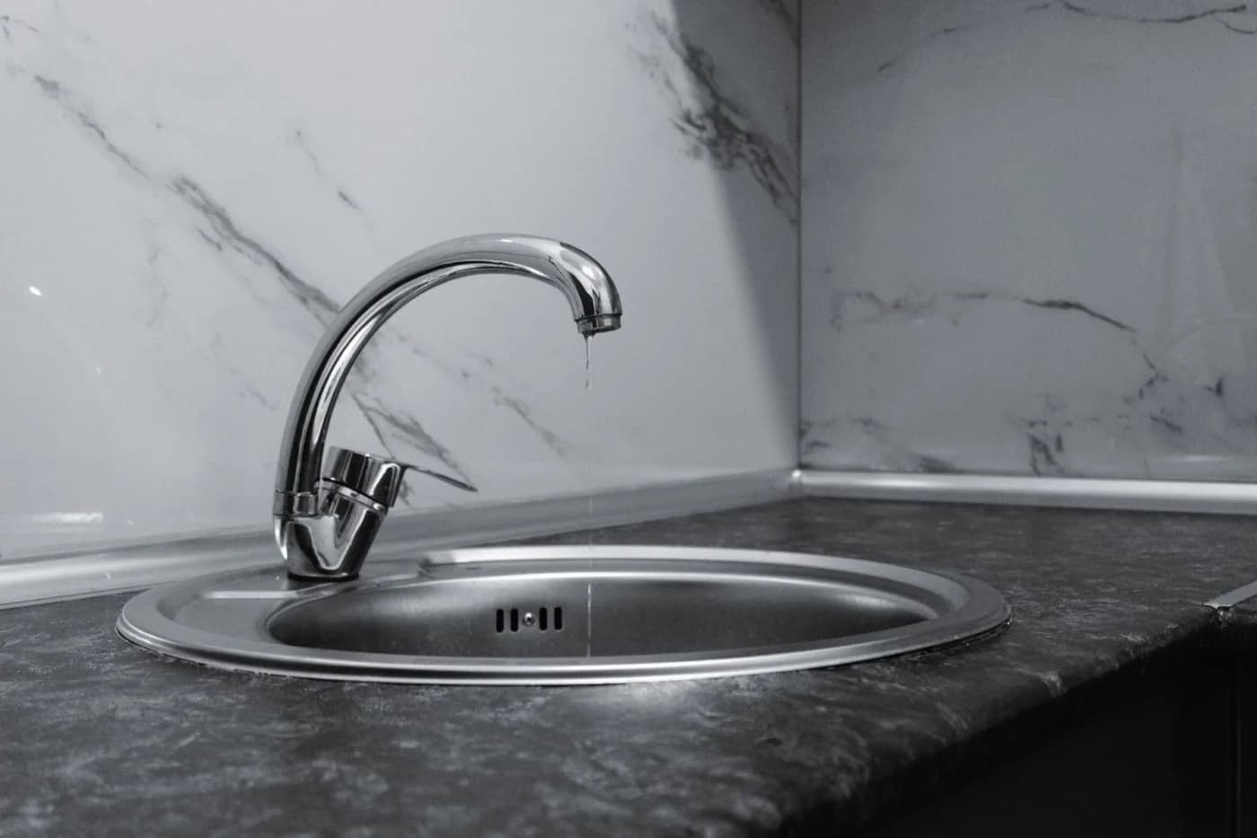 Modern kitchen faucet with water running into a stainless sink