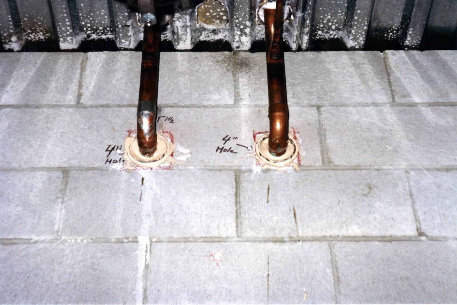Copper supply lines running through a framed floor with fire-stop collars