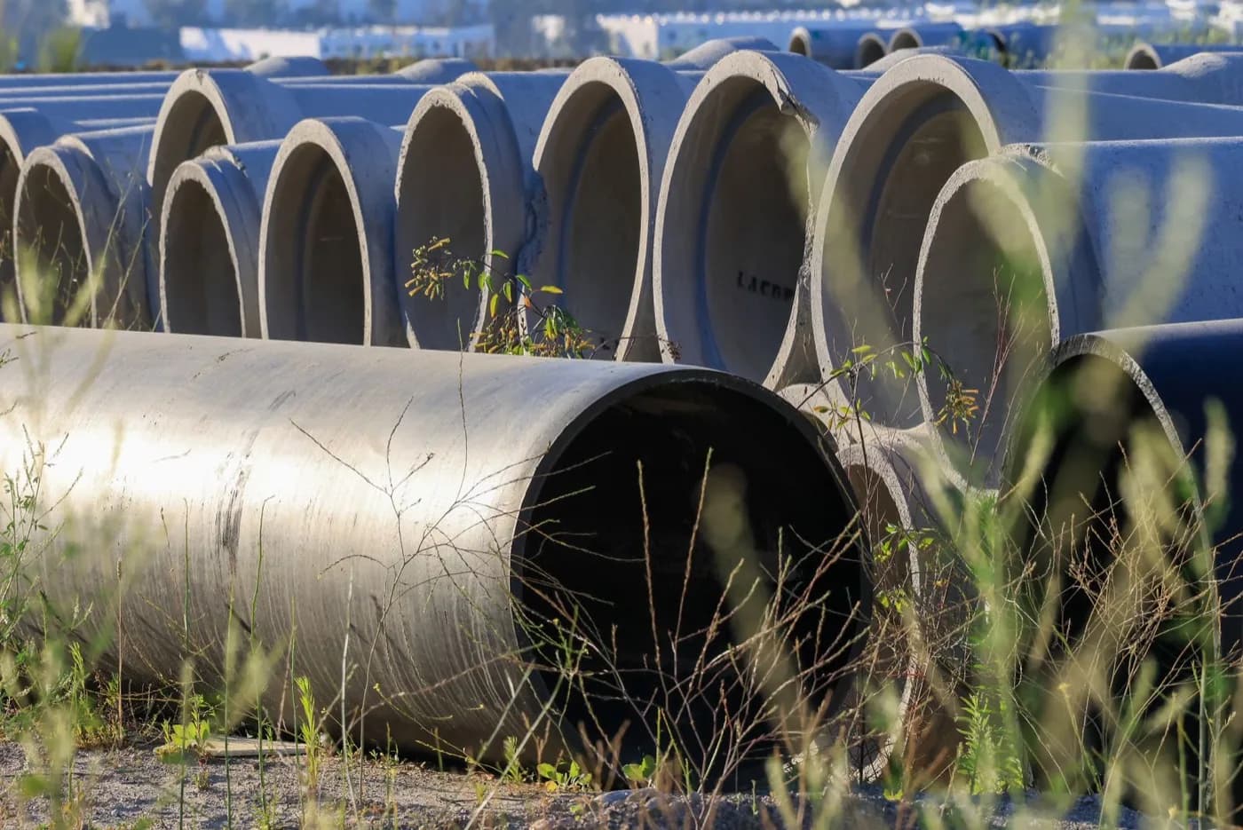 Stacked concrete sewer pipe sections in an outdoor yard